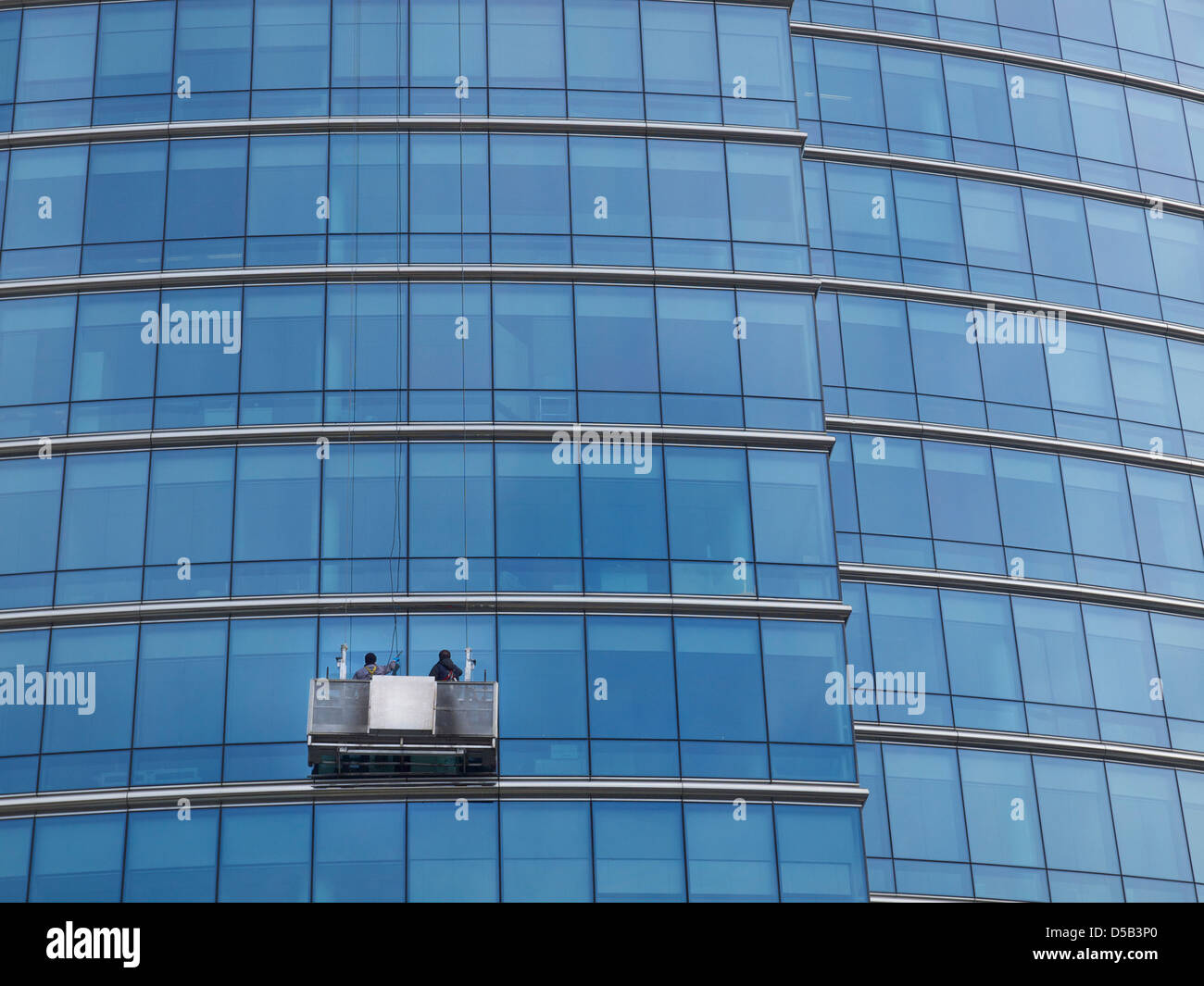 Fensterputzer arbeitet an einem Glas verkleidet Bürogebäude in Brüssel, Belgien Stockfoto