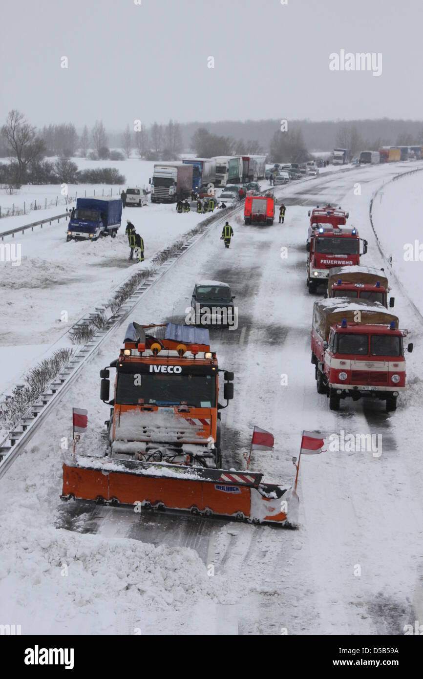 Feuerwehrleute und ein Salzstreuer kostenlos die Straßen von Schneemassen auf der A20 zwischen Guetzkow und Jarmen, Deutschland, 10. Januar 2010. Mit eisigen Temperaturen streckte sich über 300 Menschen in ihren Autos über Nacht auf der gesperrten Autobahn A20. Foto: Stefan Hoeft Stockfoto