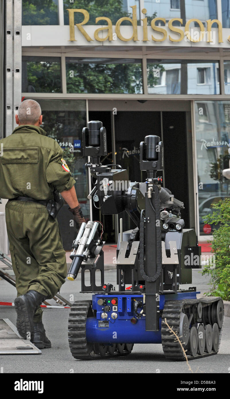 Ein Polizist remote Kontrollen einen Roboter für eine verlassene Koffer in einem vier-Sterne-Hotel in Erfurt, Deutschland, 11. August 2010 zu öffnen. Rund 85 Gäste und das Personal waren Evacuted vom Hotel entfernt. Foto: Martin Schutt Stockfoto