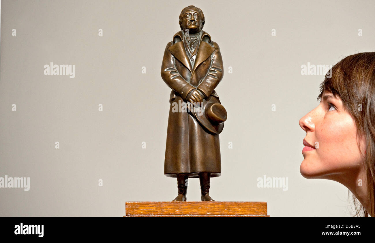 Ein weibliche Besucher untersucht eine Skulptur aus Bronze des deutschen Künstlers Mathieu Molitor von 1926 am Bildermuseum, Museum der schönen Künste in Leipzig, Deutschland, 11. August 2010. Die Skulptur zeigt der deutsche Dichter und Autor Johann Wolfgang von Goethe. Stockfoto