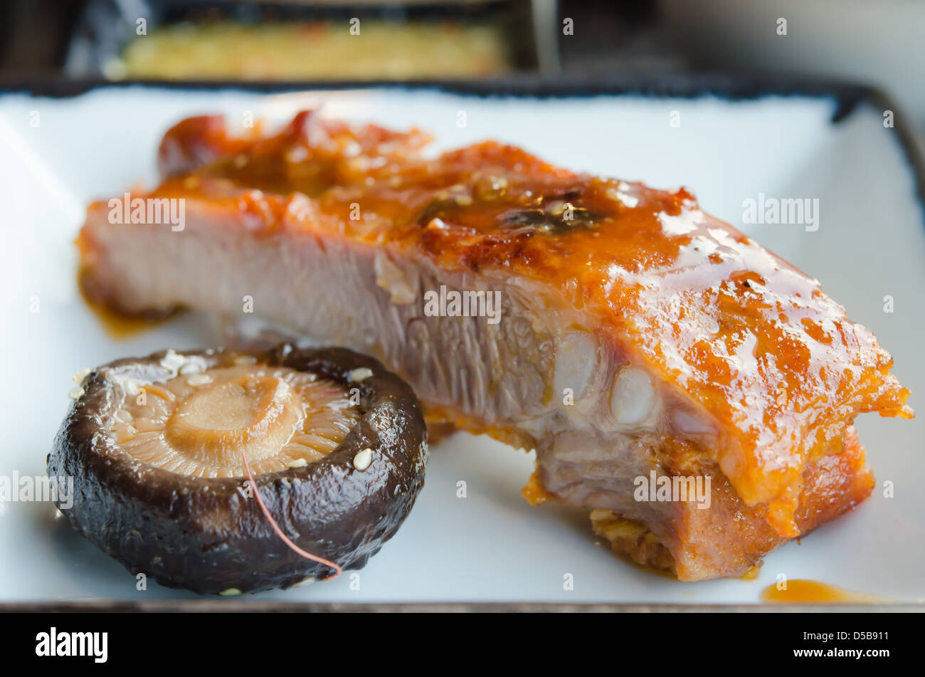 Schweinefleisch Spareribs mit roter Soße und Pilzen Stockfoto