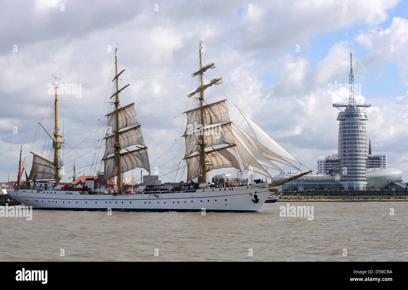 Das Führungsschiff der Schiffs-Parade der Windjammerparade "Sail 2010" geht der drei-Mast-Bark "Gorch Fock" der deutschen Marine, die "Klimahouse" und das Sail City Hotel von den Havenwelten in Bremerhaven, Deutschland, 25. August 2010. Mehr als 200 Schiffe aus 15 Nationen beteiligen sich an dem maritimen Festival (25-29 August 2010). Rund 1 Million Besucher werden erwartet, um die Stockfoto