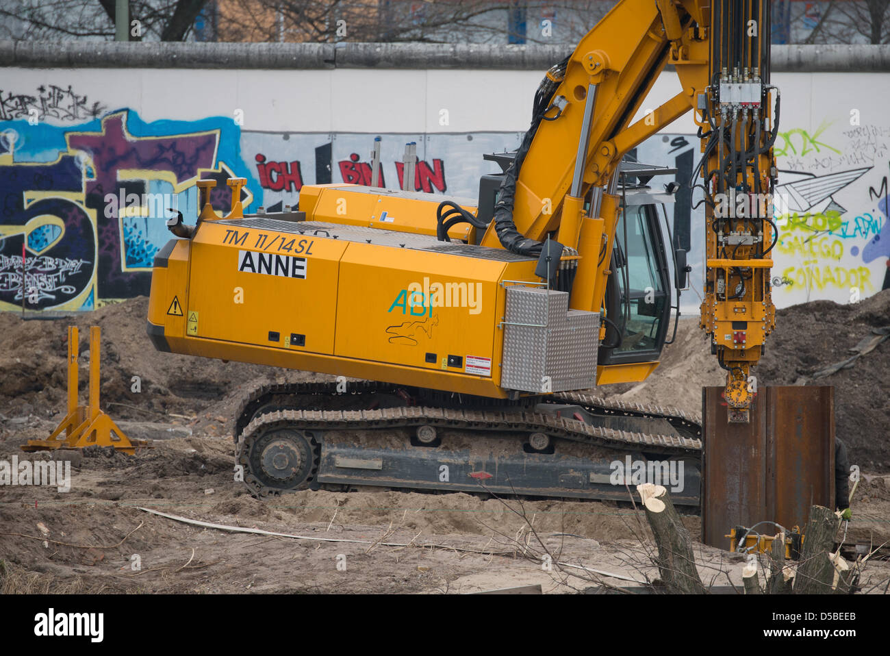 Eine Baumaschine arbeitet hinter der ehemaligen Berliner Mauer an der East Side Gallery in Berlin, Deutschland, 28. März 2013. Vier Elemente der Mauer wurden entfernt, um Platz für einen Zugang zu einer Baustelle zu machen. Ein Investor plant ein Hochhaus-Wohnung auf dem Grundstück direkt an der Spree. Foto: SOEREN STACHE Stockfoto