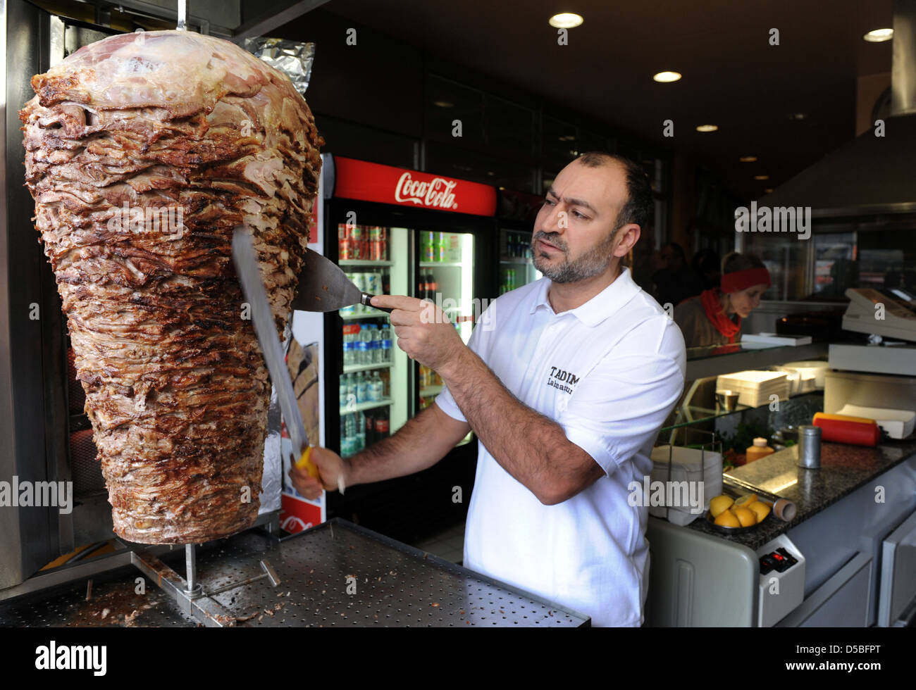 Berlin, Deutschland, schneidet ein Verkäufer Fleisch aus einem Doenerspiess Stockfoto