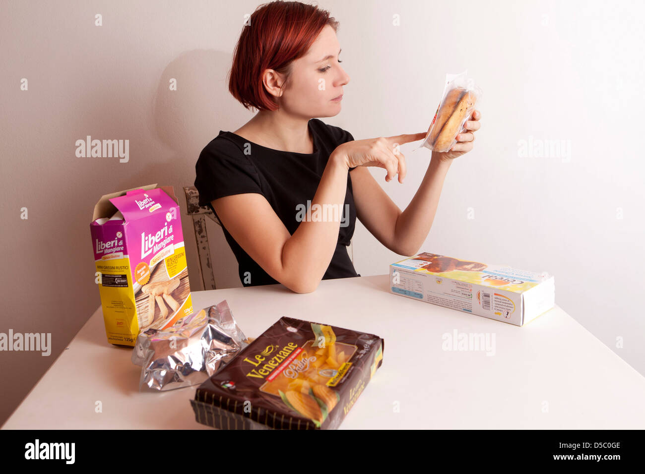 Frau liest die Zutaten eines Lebensmittels Stockfoto