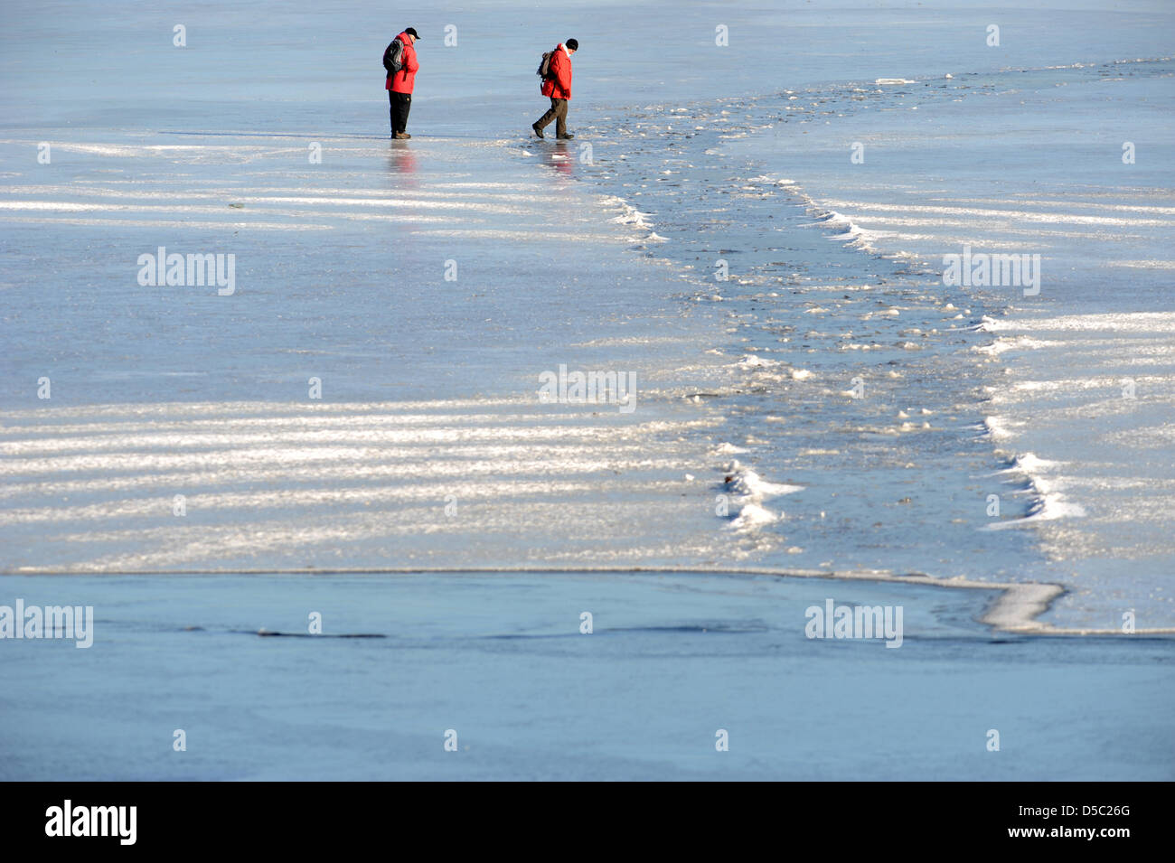 Zwei Fußgänger überqueren Sie die gefrorenen Außenalster in Hamburg, Germany, 26. Januar 2010. Doch misst das Eis auf der Außenalster 16cm, die noch nicht Zugang zu den Gewässern ermöglicht. Nach Meterologists bleiben die Temperaturen im Norden immer noch weit unter dem Gefrierpunkt. Foto: Marcus Brandt Stockfoto