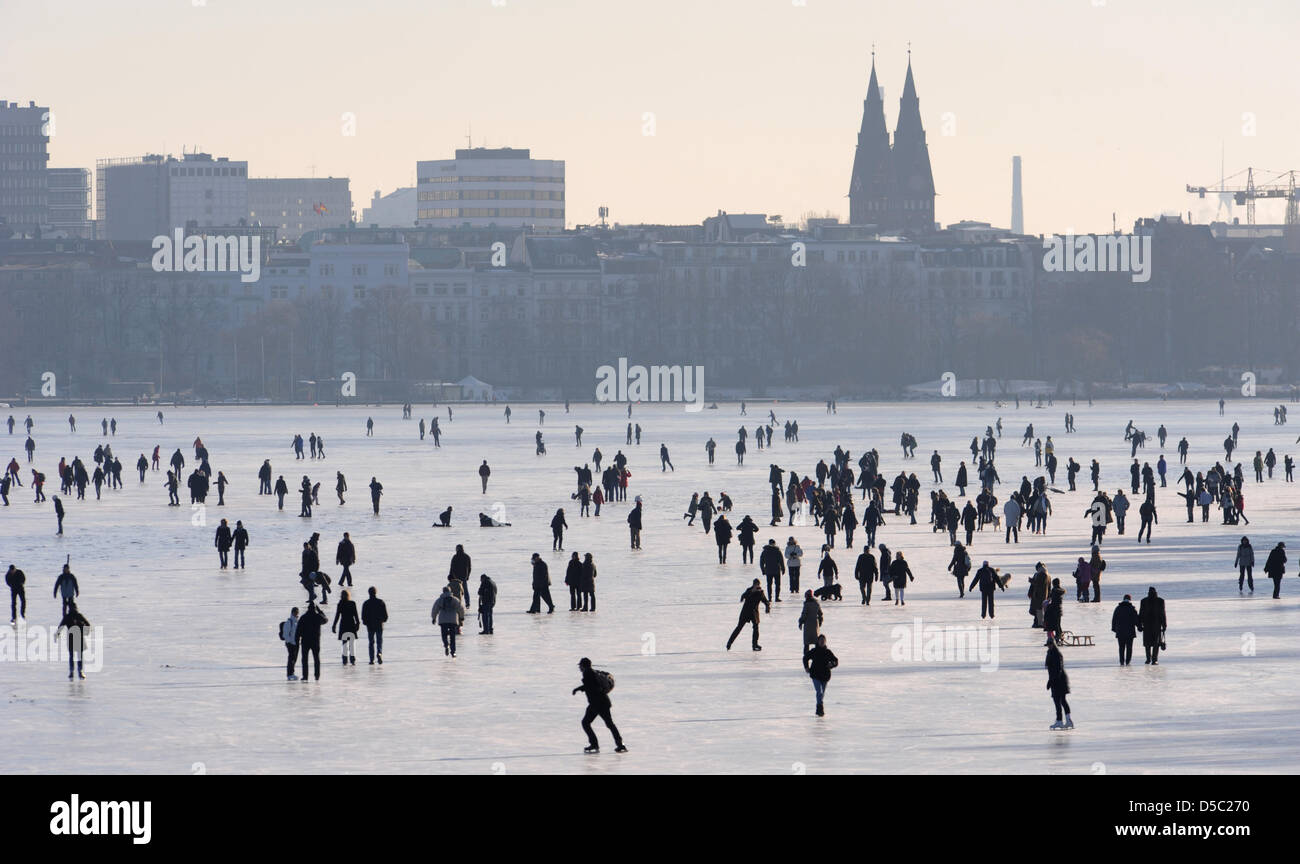 Eisläufer und Fußgänger überqueren Sie die gefrorenen Außenalster in Hamburg, Germany, 26. Januar 2010. Doch misst das Eis auf der Außenalster 16cm, die noch nicht Zugang zu den Gewässern ermöglicht. Nach Meterologists bleiben die Temperaturen im Norden immer noch weit unter dem Gefrierpunkt. Foto: Marcus Brandt Stockfoto