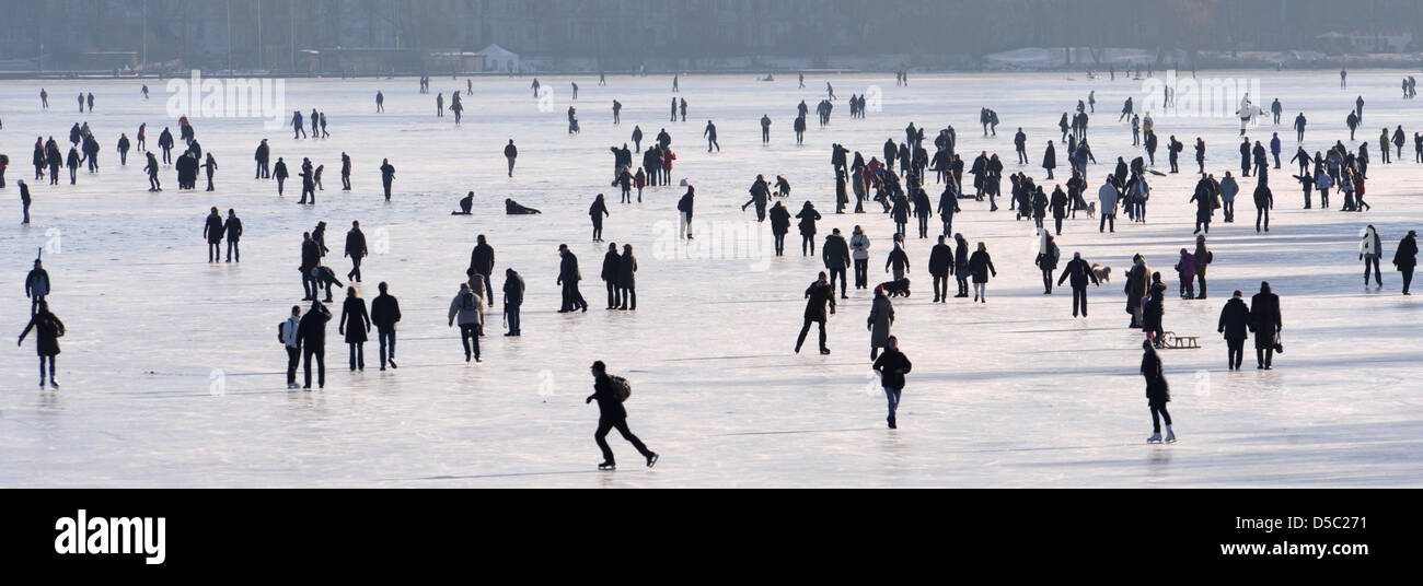Eisläufer und Fußgänger überqueren Sie die gefrorenen Außenalster in Hamburg, Germany, 26. Januar 2010. Doch misst das Eis auf der Außenalster 16cm, die noch nicht Zugang zu den Gewässern ermöglicht. Nach Meterologists bleiben die Temperaturen im Norden immer noch weit unter dem Gefrierpunkt. Foto: Marcus Brandt Stockfoto