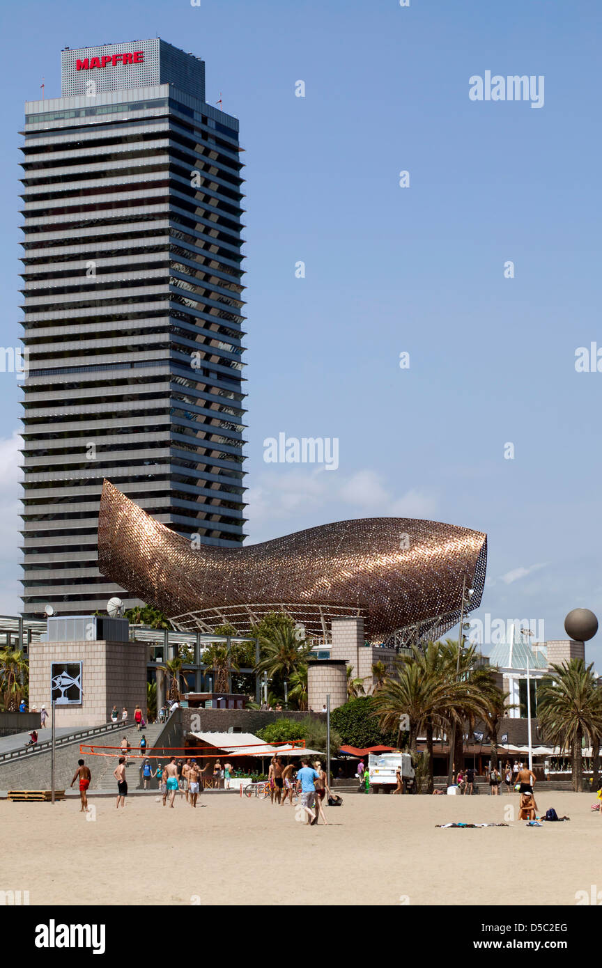 Blick auf den Strand bei Port Olimpic in Barcelona, Spanien. Das Bild bietet die Peix, Skulptur und der Torre Mapfr. Stockfoto