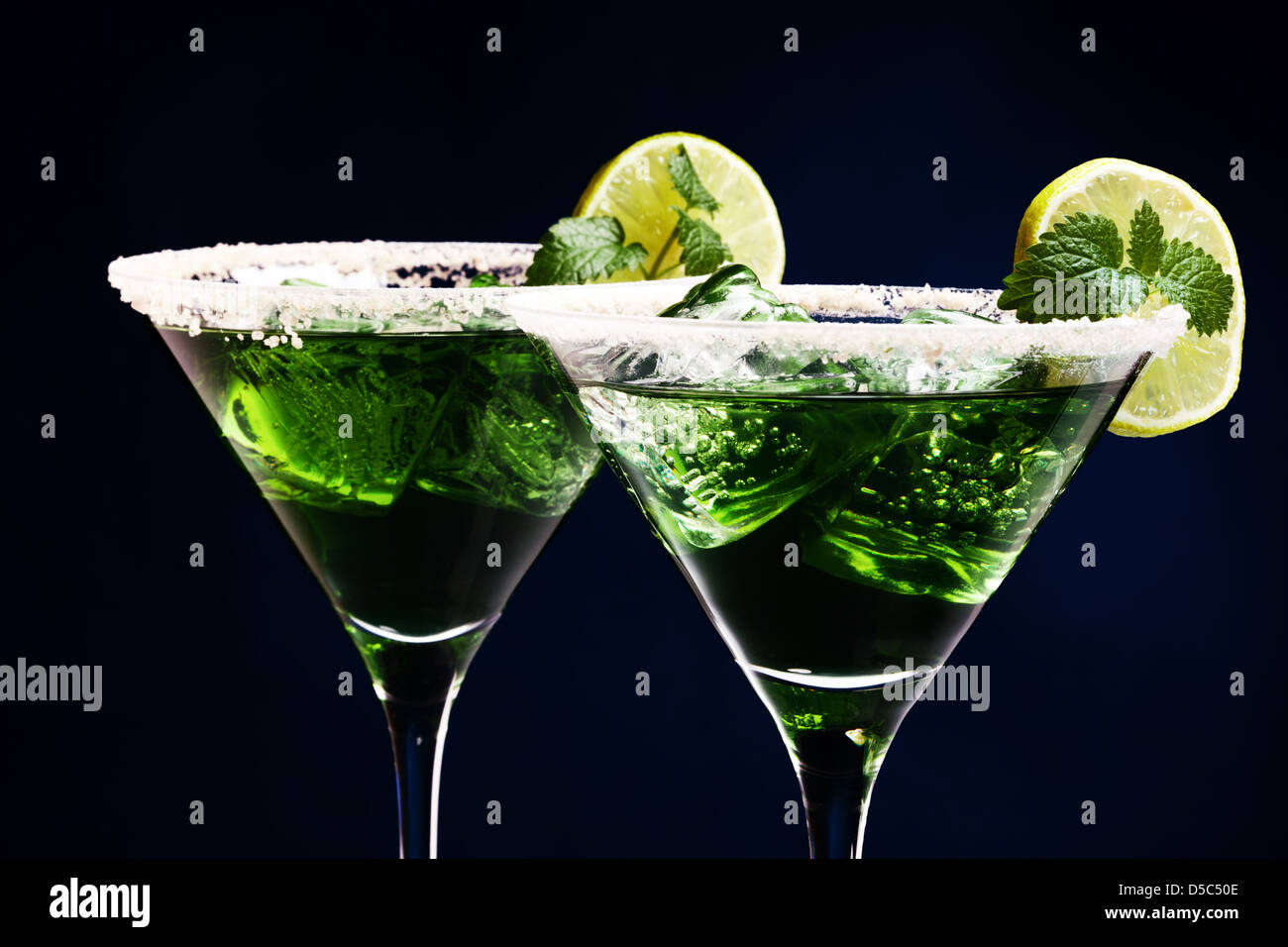 Grüne Cocktails in der Martini-Gläser mit gezuckerten Kanten, Limettenscheibe, Eiswürfel, Blatt Minze Stockfoto