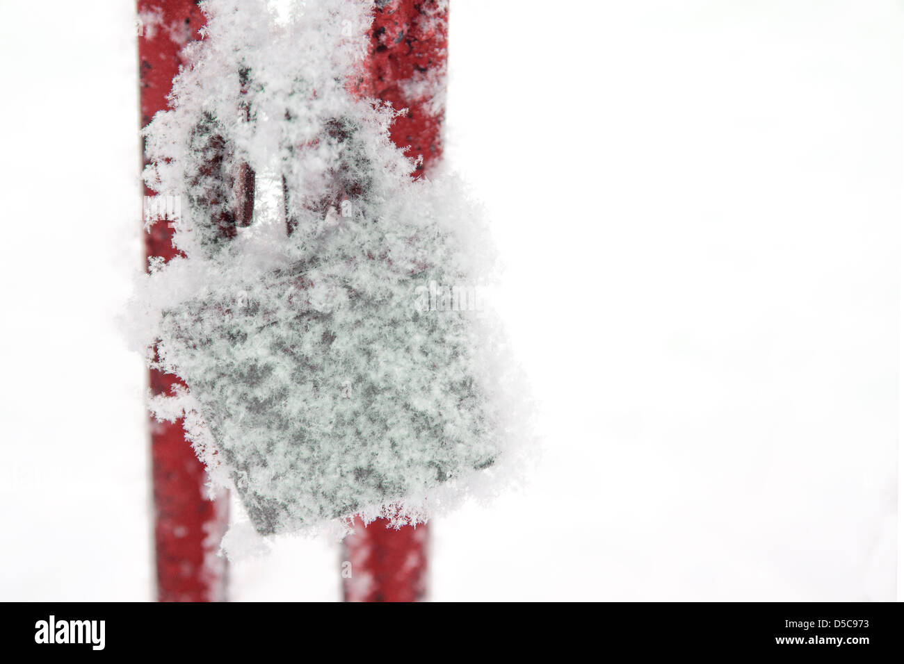Schneebedeckte Retro-Vorhängeschloss. Symbol der Gleichgültigkeit, Verzweiflung und Depression. Stockfoto
