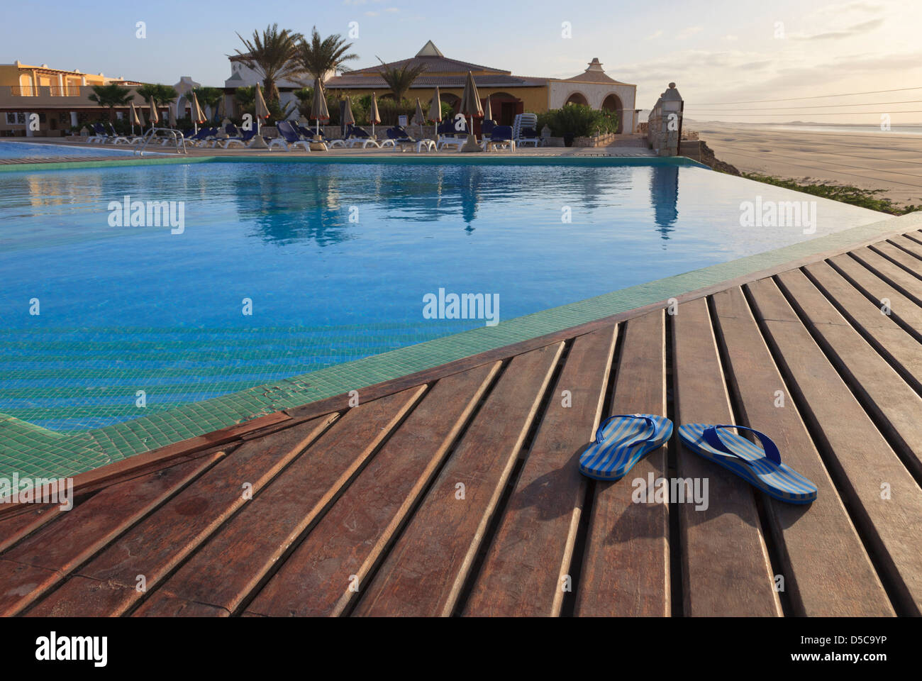 Paar Flip-flops auf Sonne decking leer Infinity-Pool in Luxus Ferienhotel auf Insel Boa Vista, Kapverden Stockfoto
