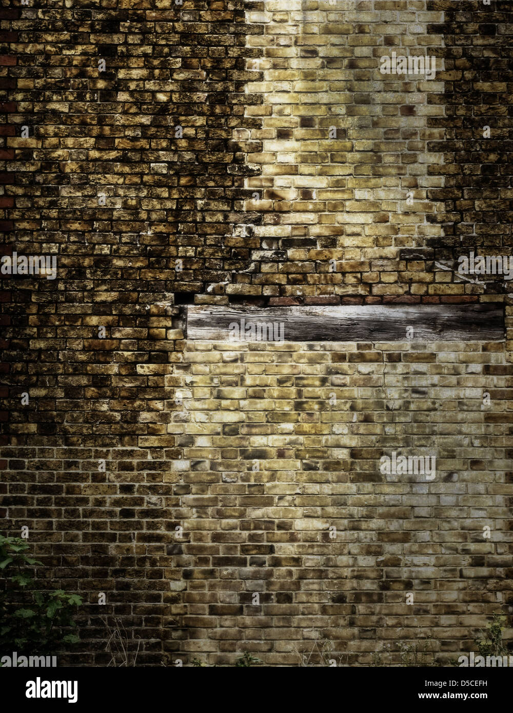 Eine alte Mauer mit einem hölzernen Türsturz. Stockfoto