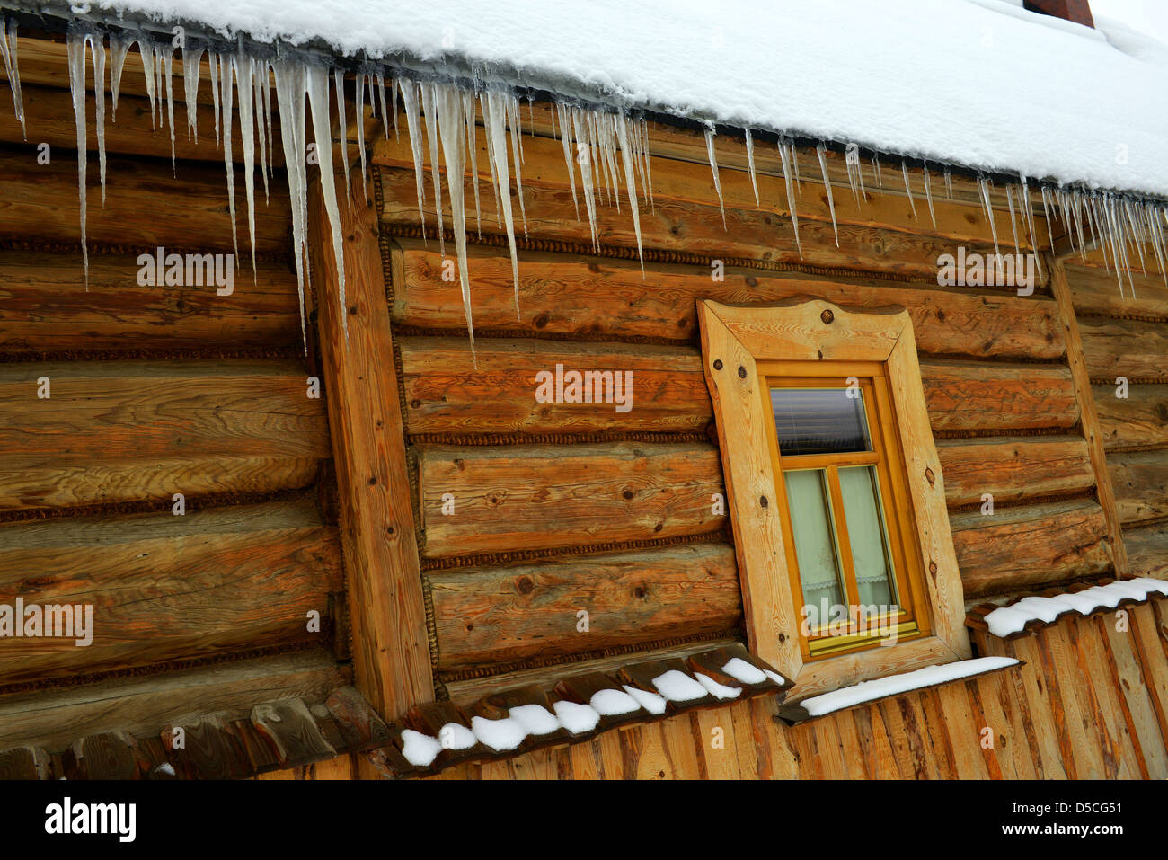 Eiszapfen und Schnee bedeckt Holzhäuser in dem malerischen Dorf Chocholow im Tatra-Gebirge in der Nähe von Zakopane Polen. Stockfoto