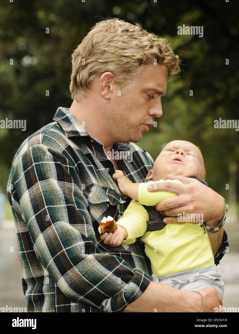 Sebastian Bezzel und Baby Mika bei einem Fototermin am Set von "Vatertage" im Olympiapark (Olympiapark). München, Deutschland- Stockfoto