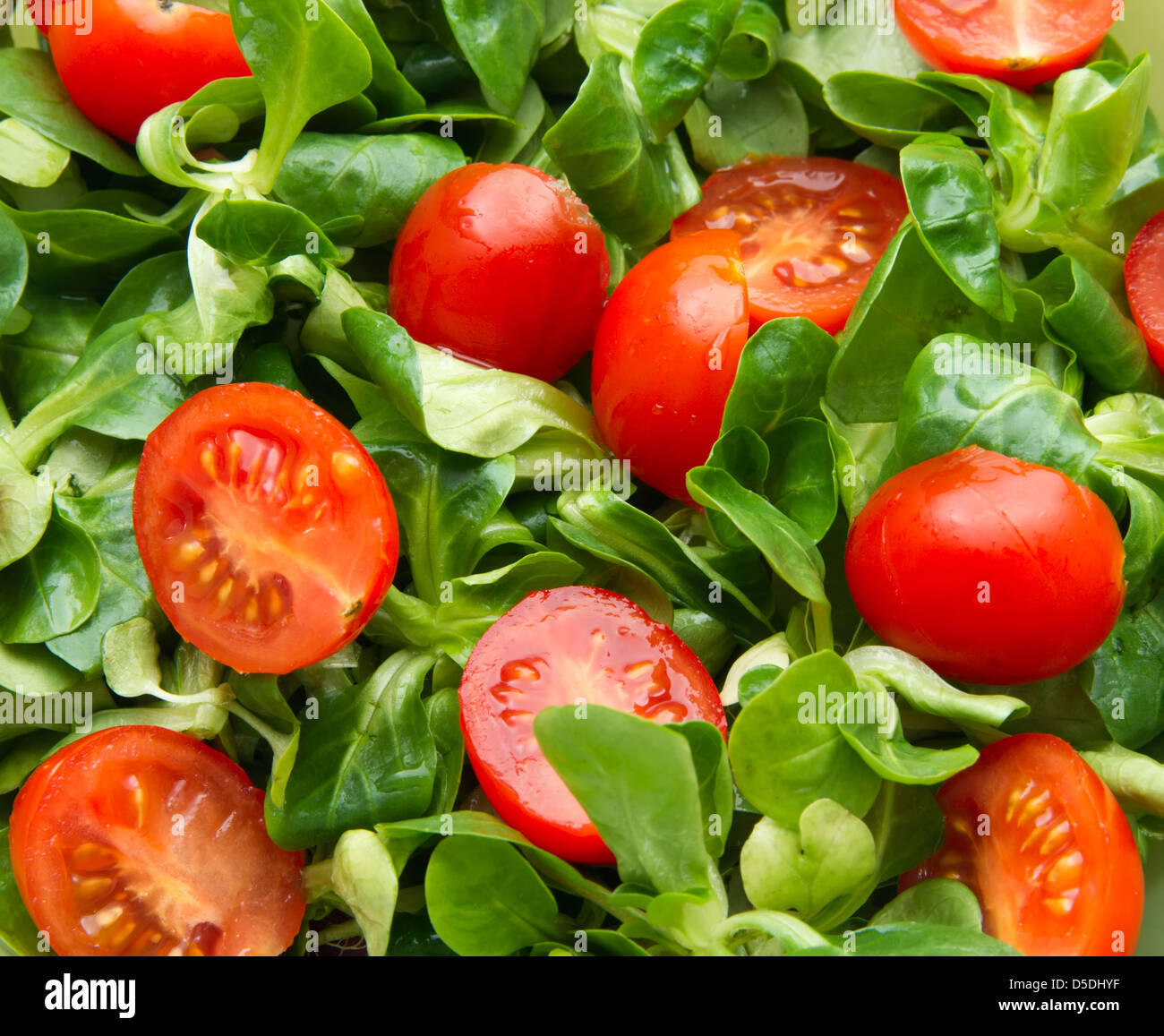 Cherry-Tomaten und Feldsalat als Hintergrund Stockfoto