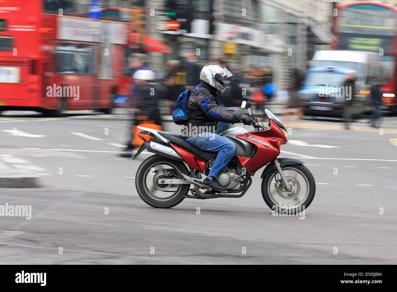 Ein Motorradfahrer herumfahren ein Kreisverkehr am Trafalgar Square in London, England. Stockfoto