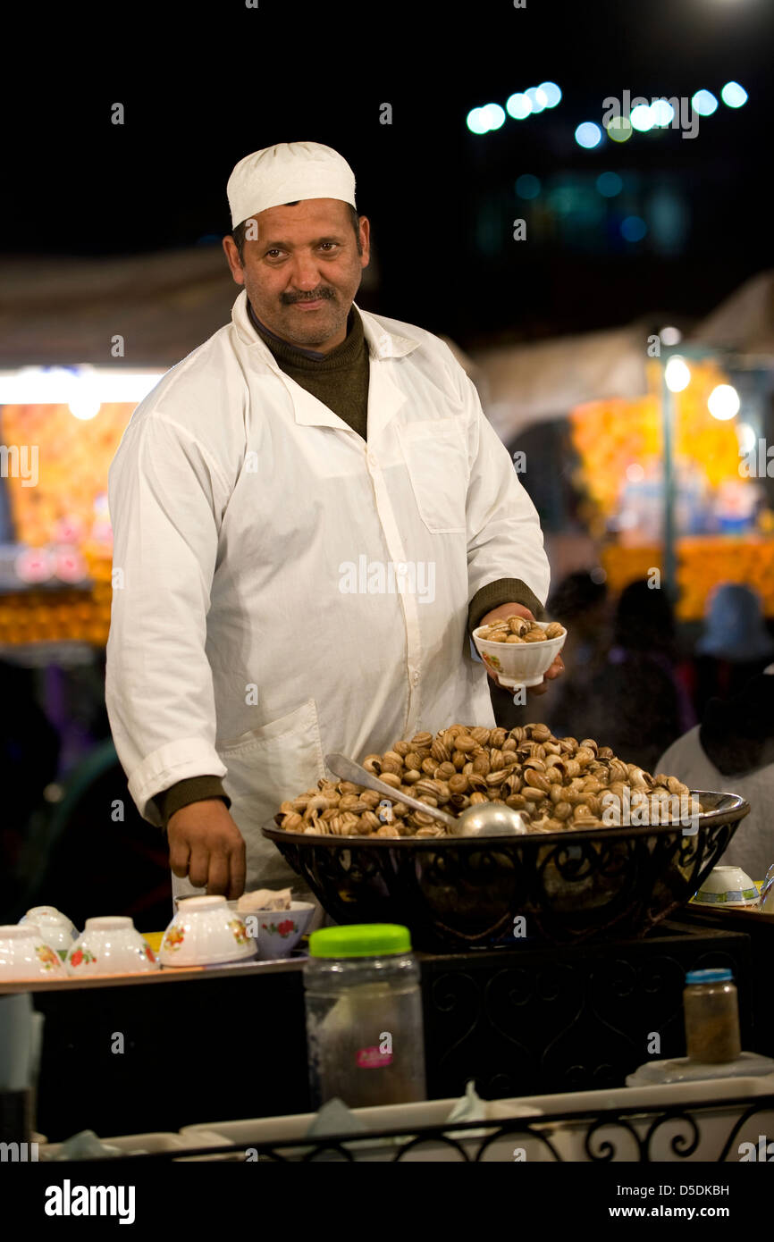 Ein Mann verkauft gekochte Schnecken auf einem Wochenmarkt Stand in Djemaa al Fna Platz in Marrkesh, Marokko Stockfoto
