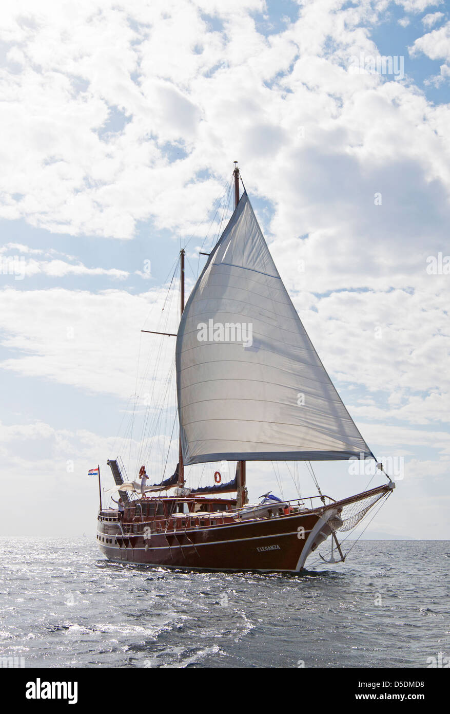 Eine traditionelle Holzschiff namens eine türkischen Gulet mit seinen Segeln, Segeln auf dem Mittelmeer an einem sonnigen Taghimmel Wolken. Stockfoto