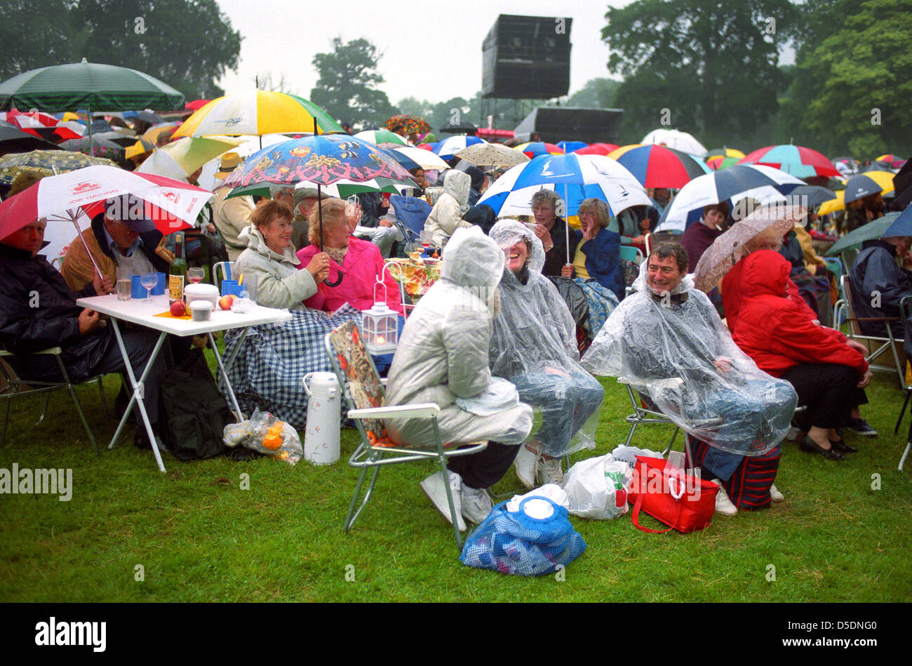 Ein Open-Air-Konzert-Publikum warten im Regen für die Show zu starten. Stockfoto