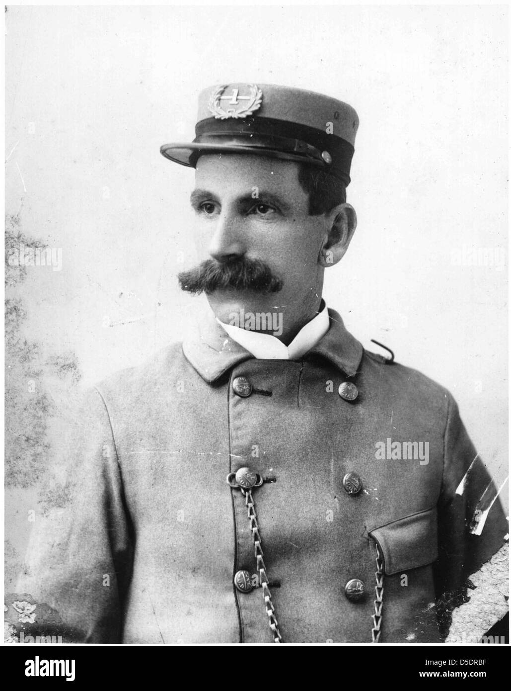 Ein Porträt eines US-Briefträgers aus der Zeit um 1880, das die Uniform und Accessoires des Postarbeiters wie eine Taschenuhr zeigt. Diese Figur repräsentiert die Rolle des Postboten im späten 19. Jahrhundert. Stockfoto