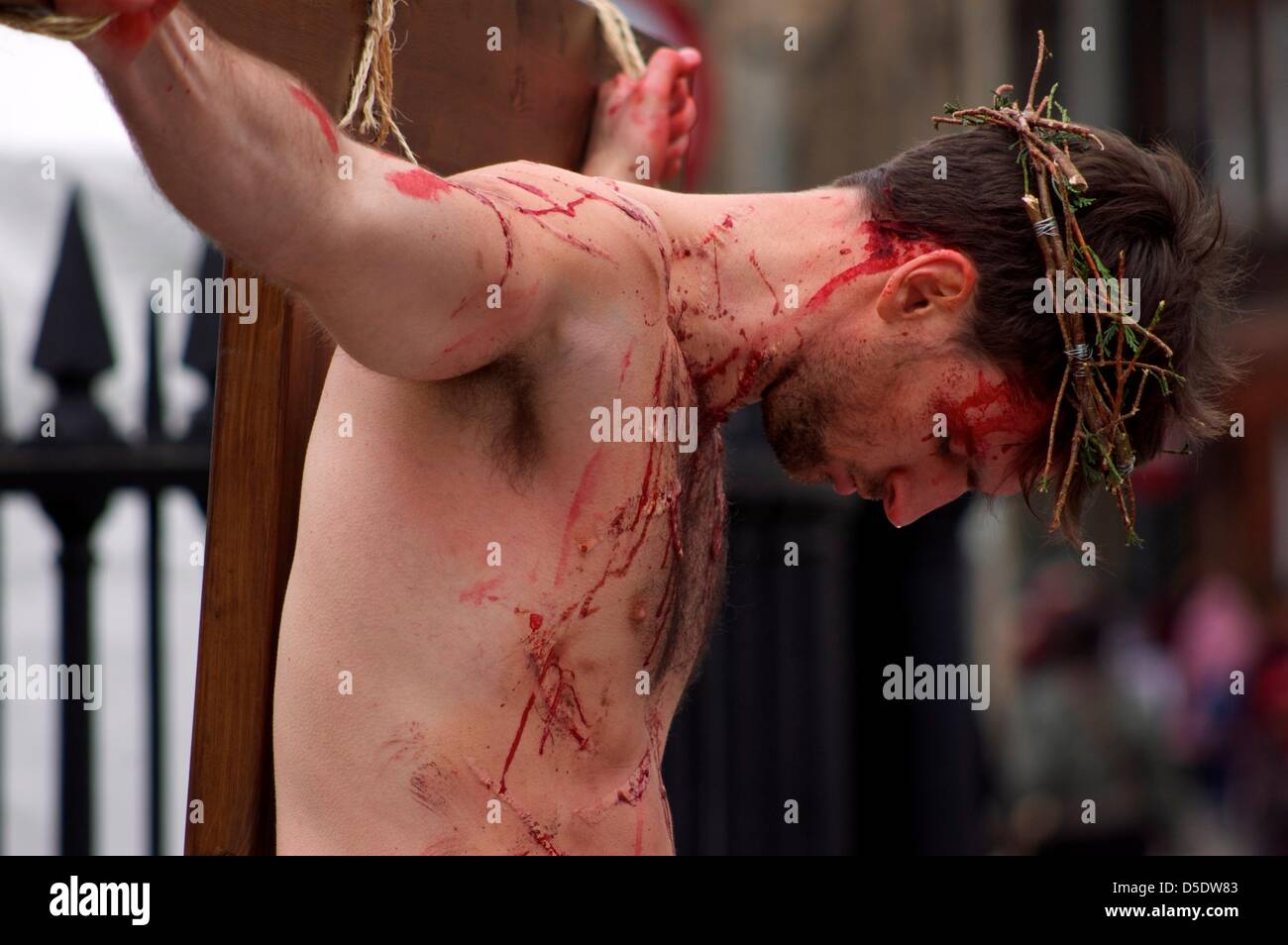 Cambridge, Cambridgeshire, Großbritannien. 29. März 2013. Ein Mann erschafft die Kreuzigung von Jesus Christus im Vorfeld bis zu Ostern auf der Königs-Parade im Schatten des Kings College, Cambridge, um der Öffentlichkeit die wahre Bedeutung von Ostern am Karfreitag zu erinnern. 29. März 2013. Stockfoto