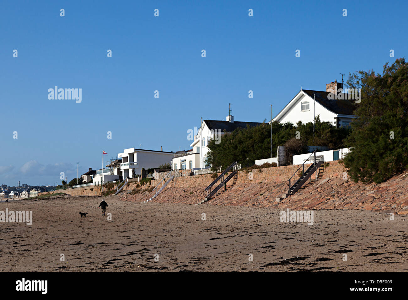 Häuser mit Strand Fassade und Mann zu Fuß Hund, St. Helier, Jersey, Kanalinseln, Großbritannien Stockfoto