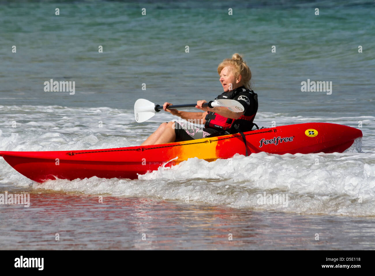 Reife Frau mit einem Kanu, Harlyn Bay, Cornwall, England Stockfoto