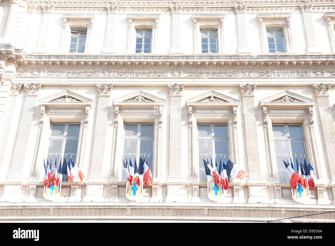 Französische Fahnen schmücken einen herrschaftlichen Altbau, Marseille, Frankreich. Stockfoto