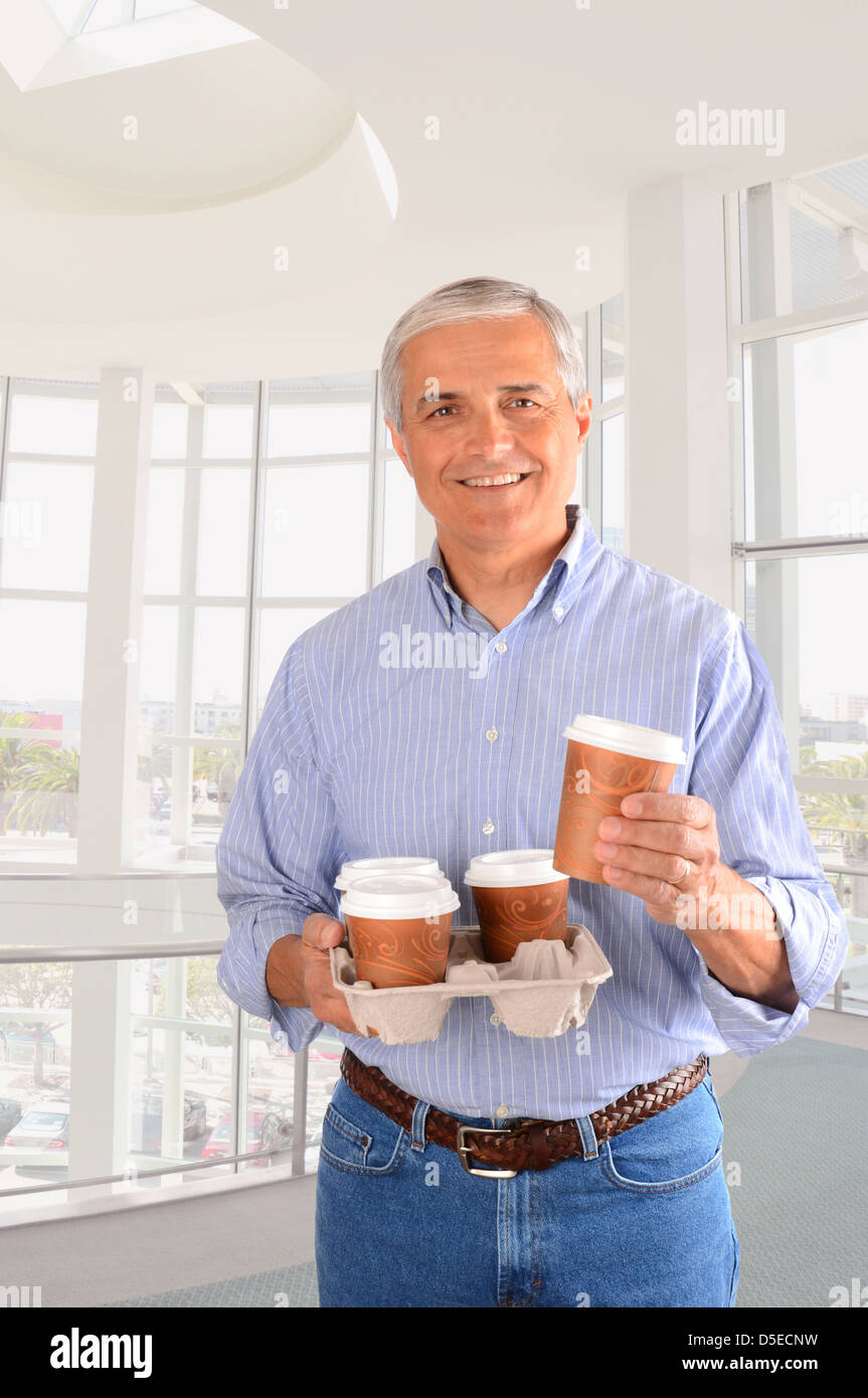Nahaufnahme eines lächelnden mittleren Alter Geschäftsmann bringen Kaffee für das Büro. Hochformat Stockfoto