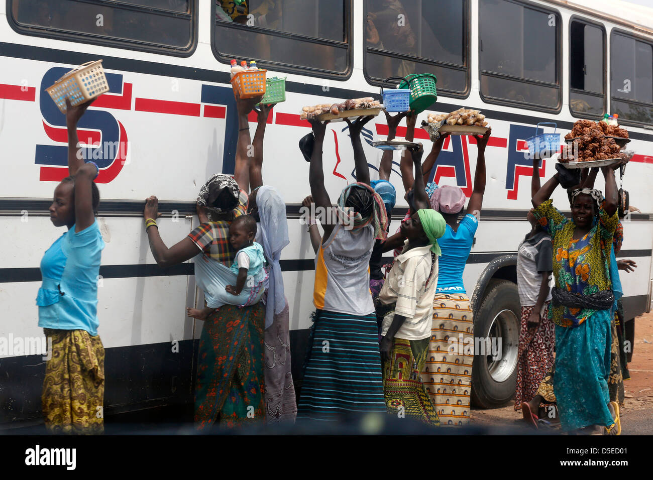 Straße Verkäufer versuchen, Erfrischungen und Früchte zum bus-Passagiere, Burkina Faso, Afrika zu verkaufen Stockfoto