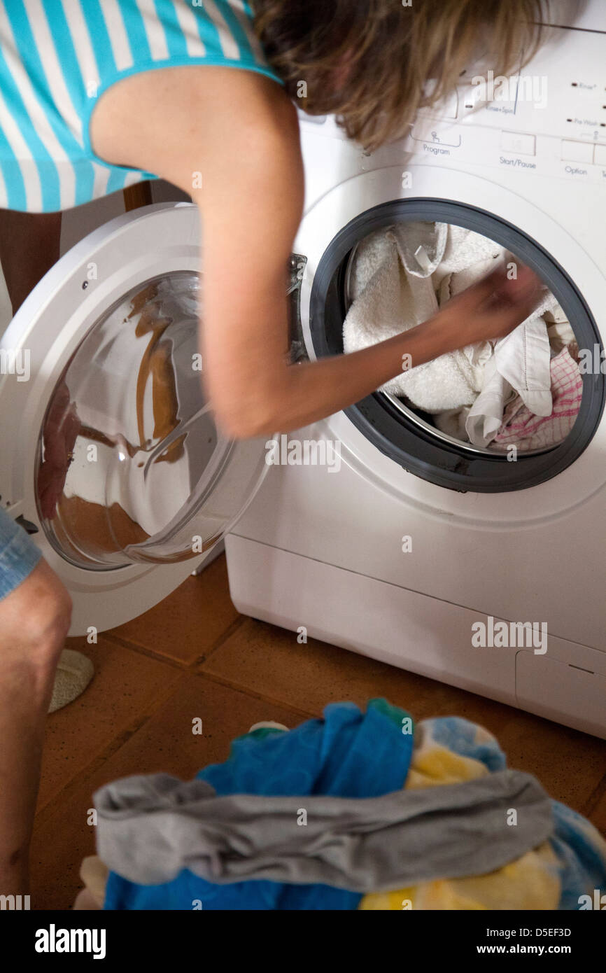 Frau, Füllung Waschmaschine Stockfoto