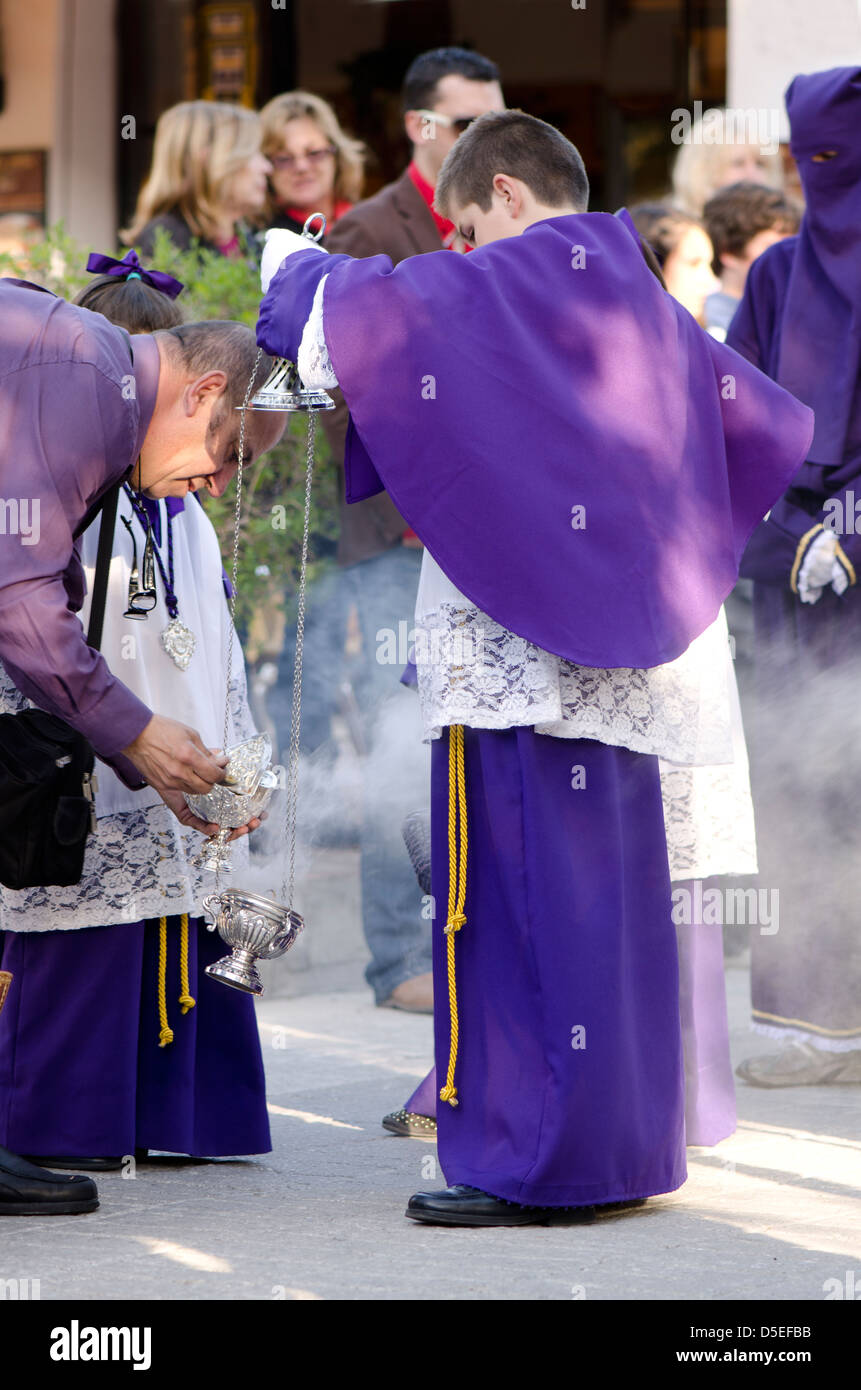 Junge, die Beleuchtung der Weihrauch-Brenner während der Prozession, der Osterwoche, der Semana Santa, Mijas Pueblo, Spanien. Stockfoto