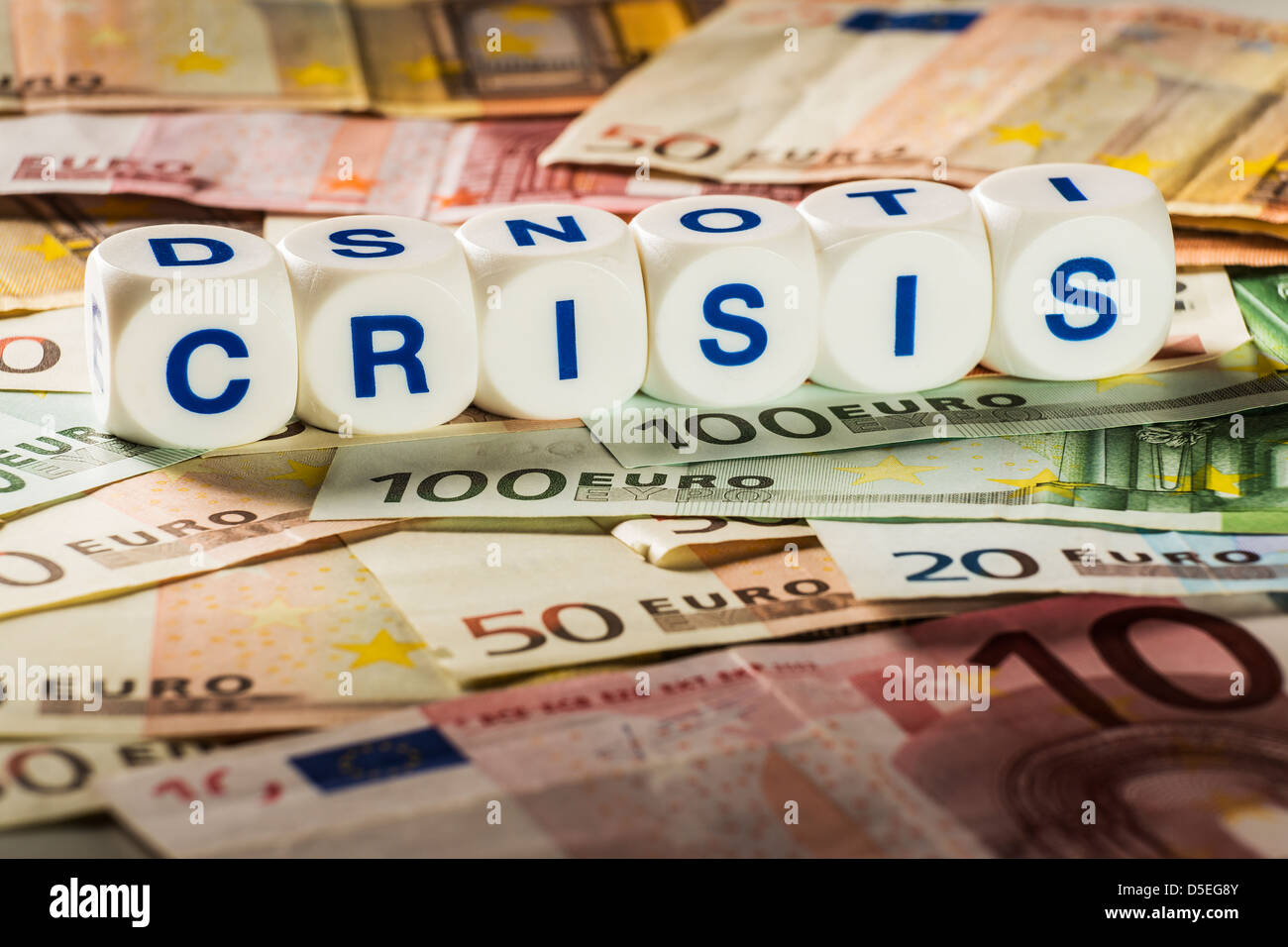 Buchstaben auf weißen Würfel mit dem Wort Krise auf Euro-Banknoten Stockfoto