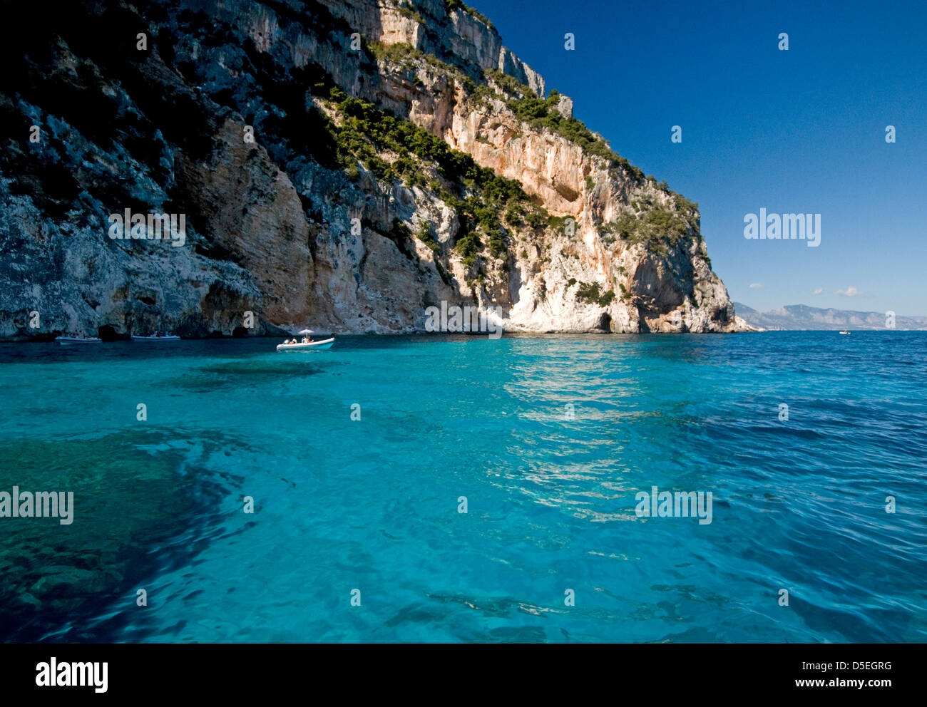 Hohe Klippen mit klaren und transparenten Wasser des Meeres an der Küste in der Nähe von Cala Mariolu Strand, Baunei, Orosei Golf, Sardinien, Italien Stockfoto