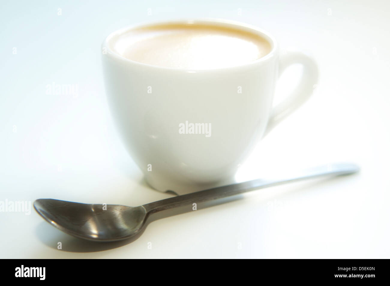 Espresso-Tasse und Löffel auf weißem Hintergrund Stockfoto
