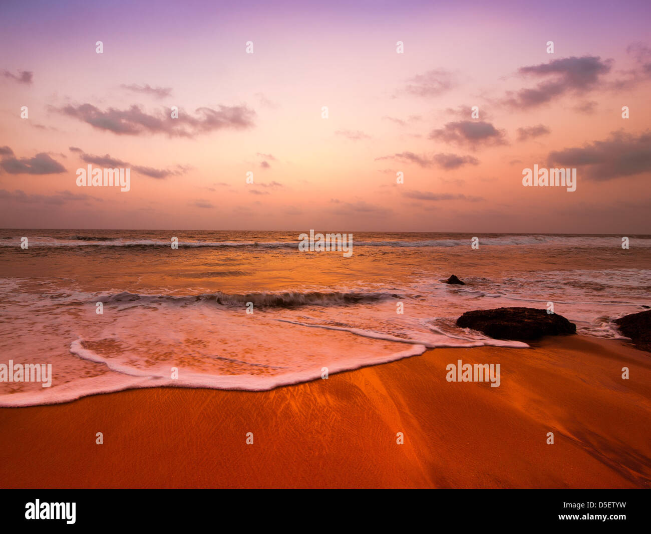 Sonnenuntergang am tropischen Strand Landschaft. Felsen an der Küste des Ozeans unter Abendsonne. Süd-Indien Stockfoto