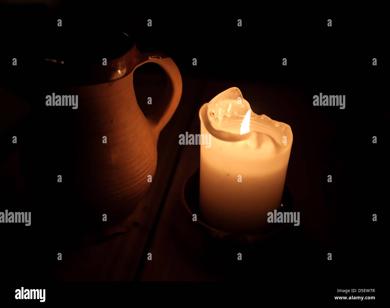 Brennende Kerze und Lehm Tasse Bier am Tisch im alten restaurant Stockfoto