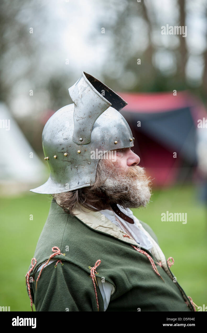 Mittleren Alter Mann mit Bart, gekleidet in mittelalterliche Kleidung und Helm auf ein Re-Enactment-Wochenende in Essex. Seite Ansicht Profilbildnis. Stockfoto