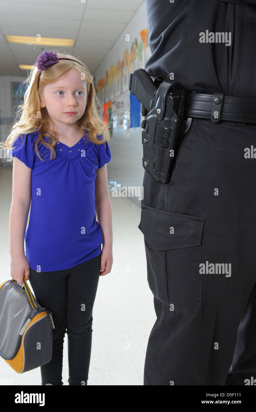 USA-Sicherheit in öffentlichen Schulen Polizist mit kleinen Mädchen in der Schule Halle Stockfoto
