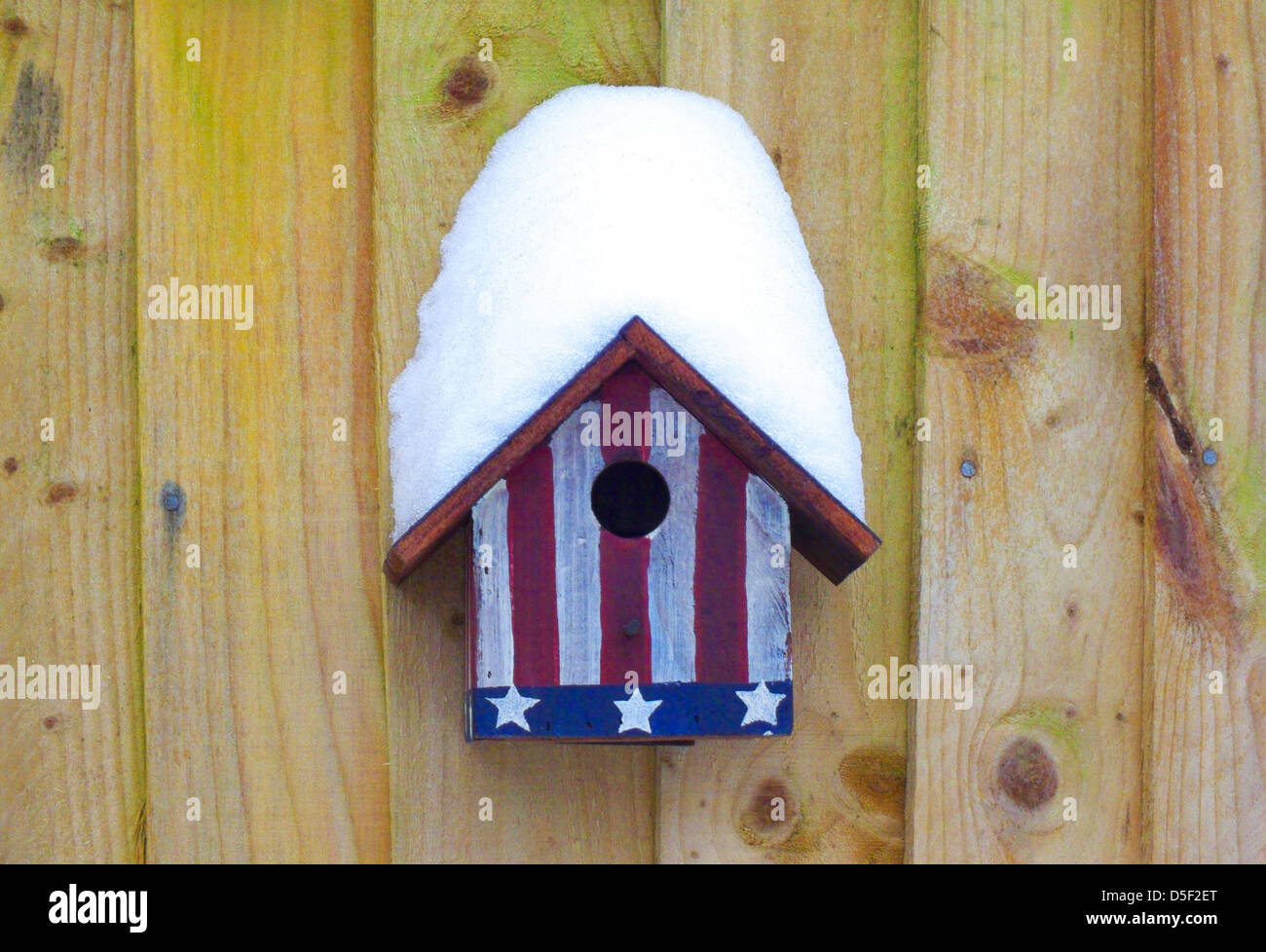 Abdeckung von Schnee auf ein Vogelhaus mit Stars And Stripes lackiert Stockfoto