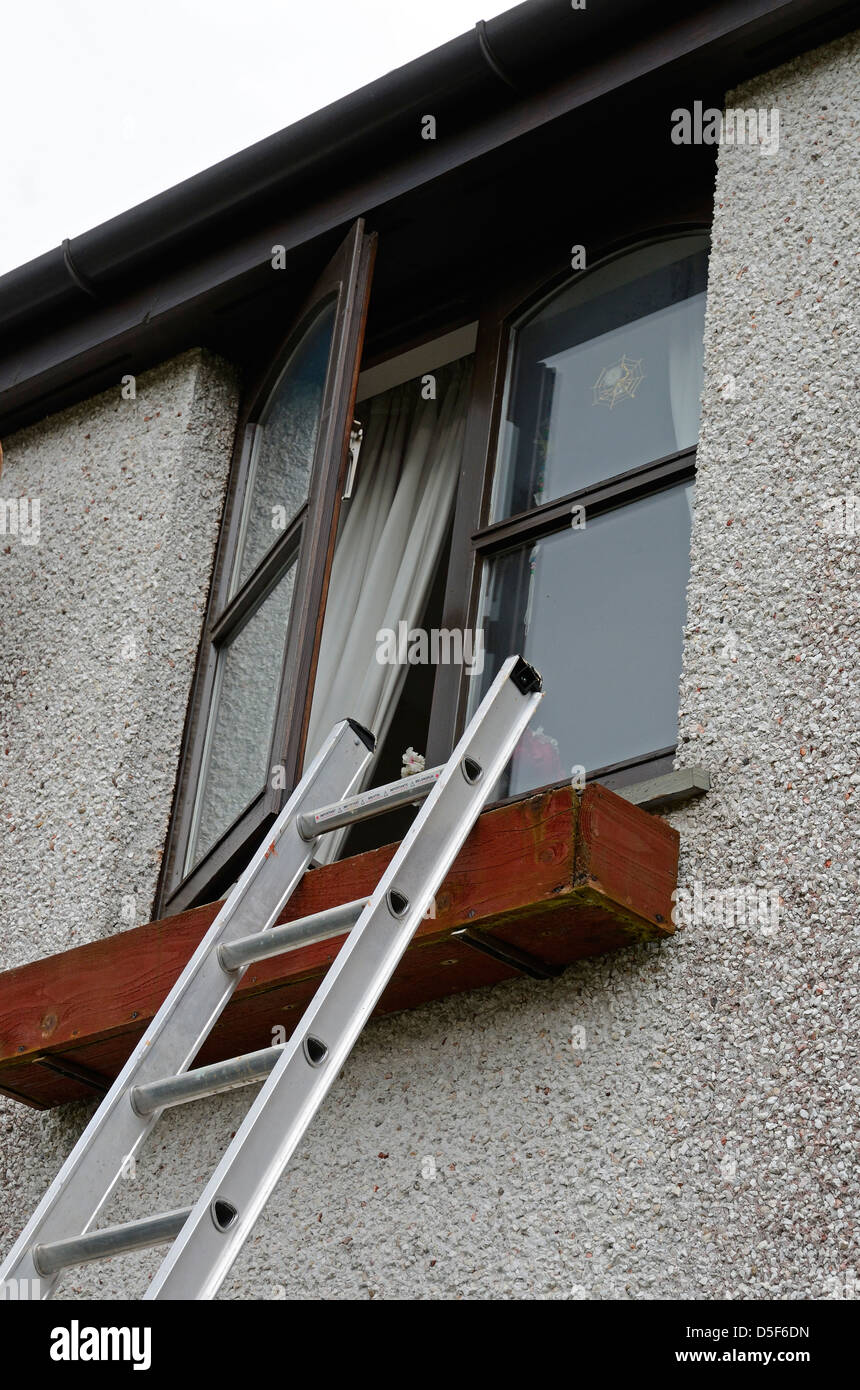 eine Leiter am offenen Fenster Stockfoto