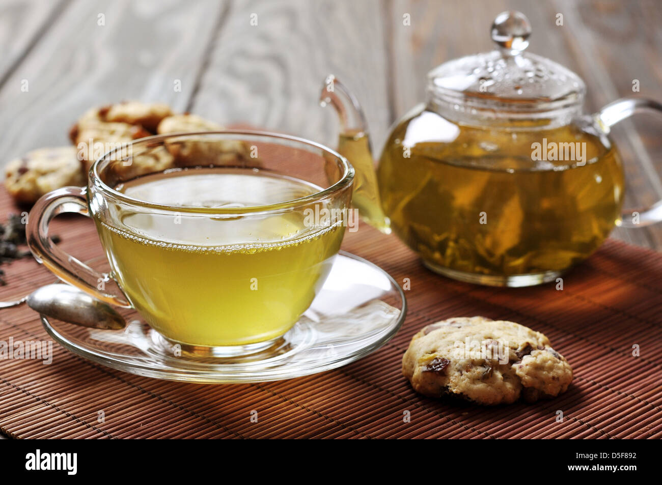 Grüner Tee in der Tasse und Teekanne mit Cookies auf hölzernen Hintergrund Stockfoto