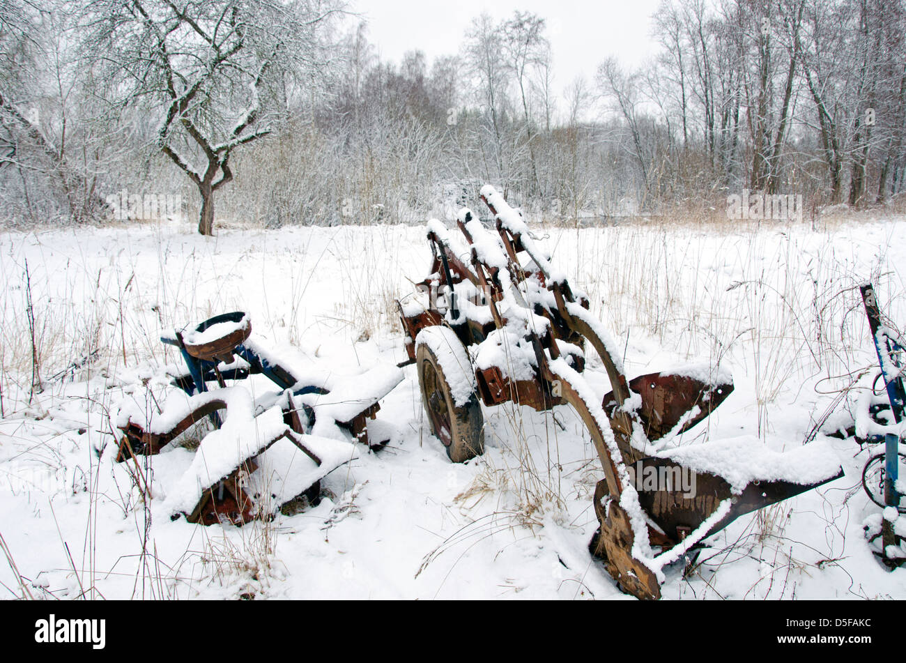 verrostet und Alter Pflug im Bauernhof mit Schnee Stockfoto