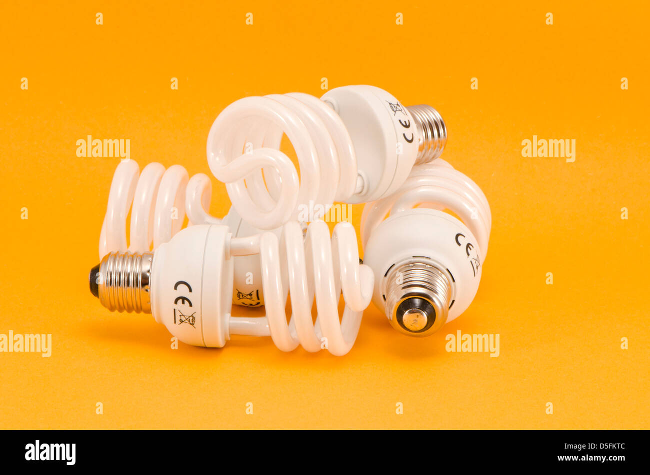 drei moderne energiesparende Glühbirnen auf gelbem Hintergrund Stockfoto