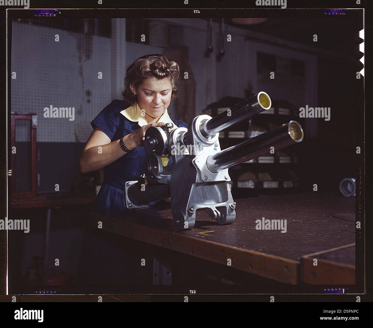 Eine junge Mitarbeiterin von North American Aviation, Incorporated, arbeitet über den Fahrwerksmechanismus eines P-51 Kampfflugzeugs, Inglewood, Kalifornien. Der Mechanismus ähnelt einer kleinen Kanone (LOC) Stockfoto