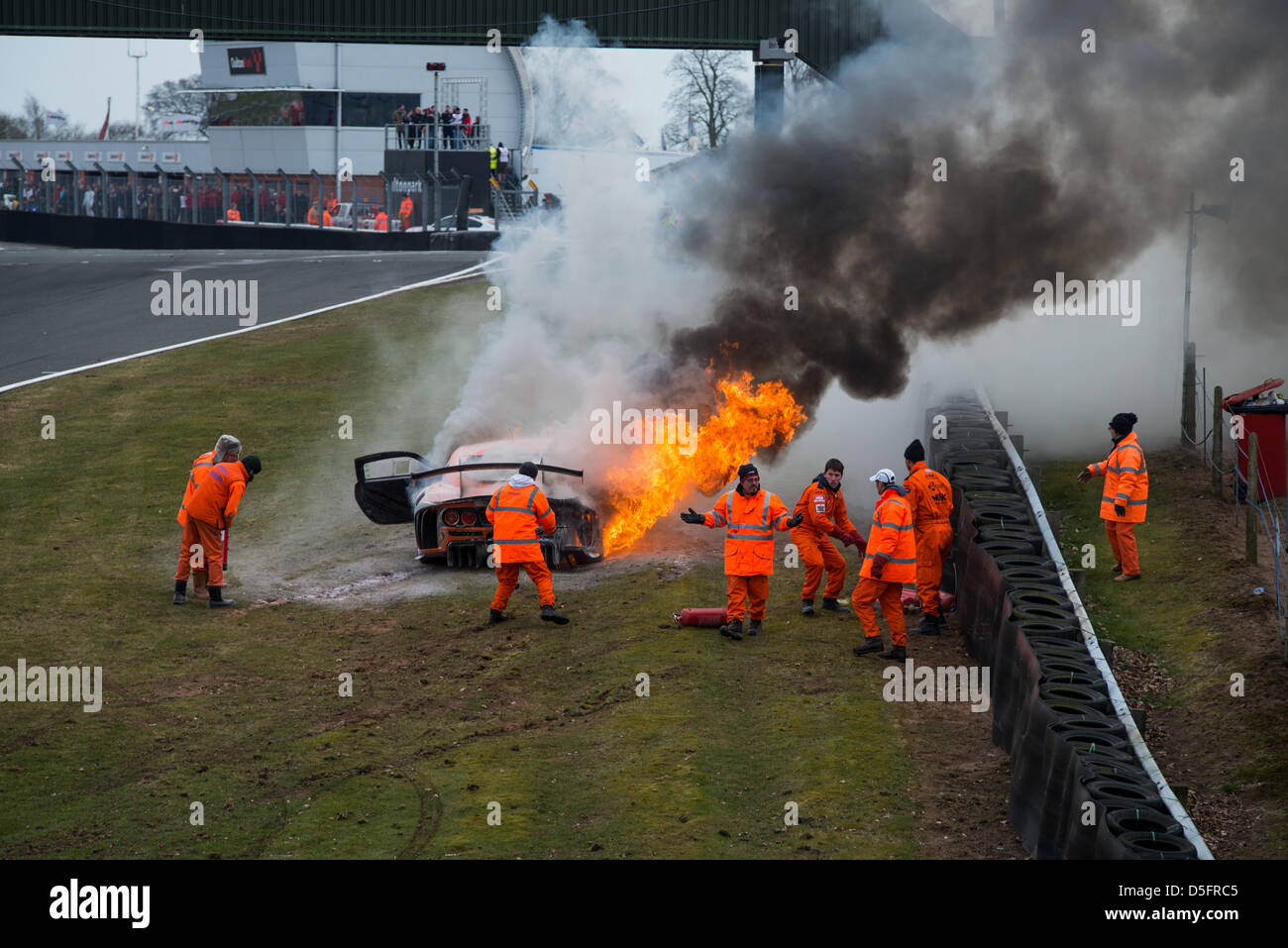 Oulton Park-Rennstrecke, Cheshire, UK. 1. April 2013. Track-Marshals Kampf um löschte das Feuer in der Ginetta G55 GT3-Auto von Tom Sharp, die nahe dem Ende des zweiten Rennens Avon Reifen British GT auf Montag, 1. April 2013 in Oulton Park-Rennstrecke, Cheshire, Vereinigtes Königreich Feuer gefangen. Bildnachweis: James Farley/Alamy Live-Nachrichten Stockfoto