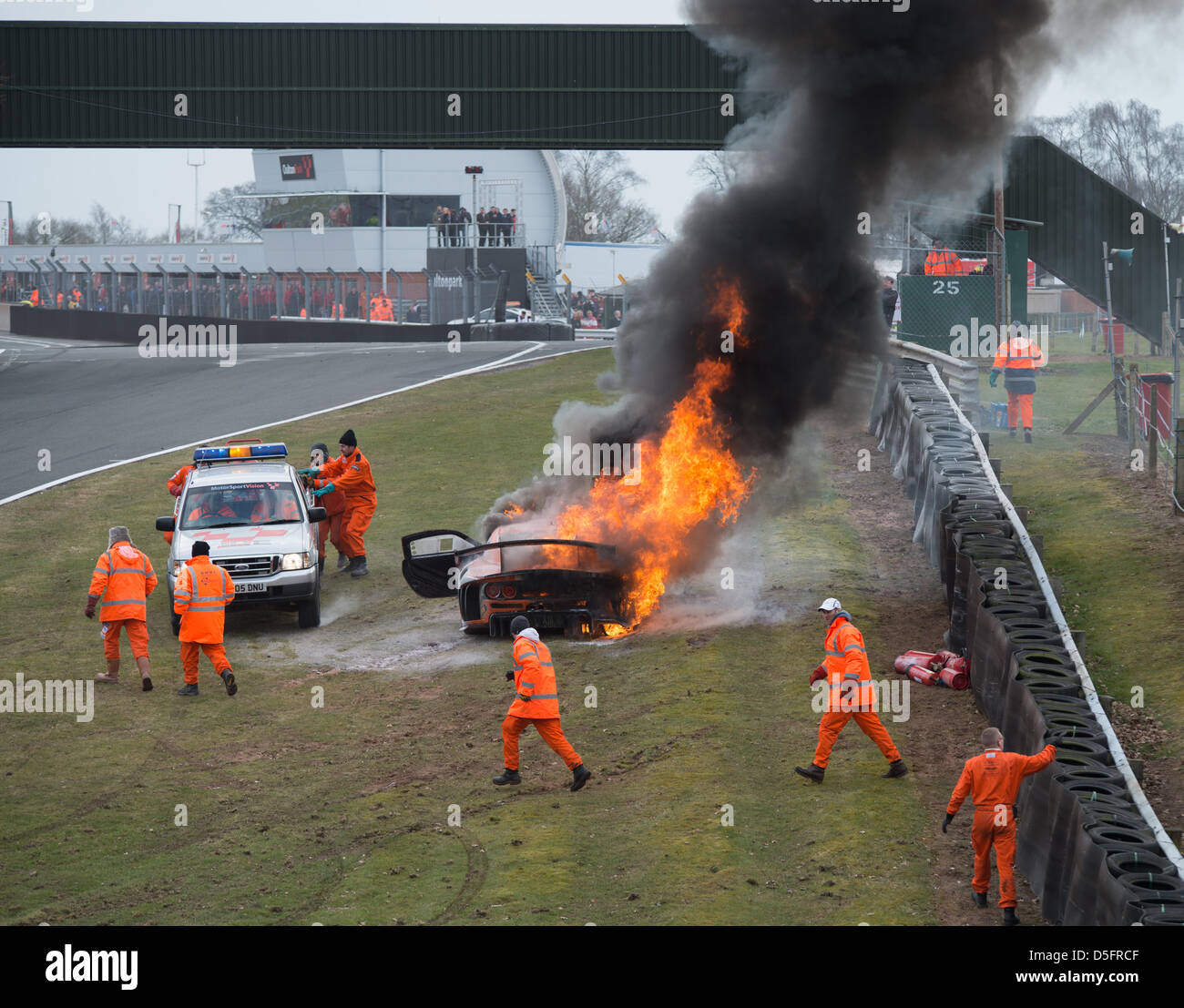 Oulton Park-Rennstrecke, Cheshire, UK. 1. April 2013. Track-Marshals Kampf um löschte das Feuer in der Ginetta G55 GT3-Auto von Tom Sharp, die nahe dem Ende des zweiten Rennens Avon Reifen British GT auf Montag, 1. April 2013 in Oulton Park-Rennstrecke, Cheshire, Vereinigtes Königreich Feuer gefangen. Bildnachweis: James Farley/Alamy Live-Nachrichten Stockfoto