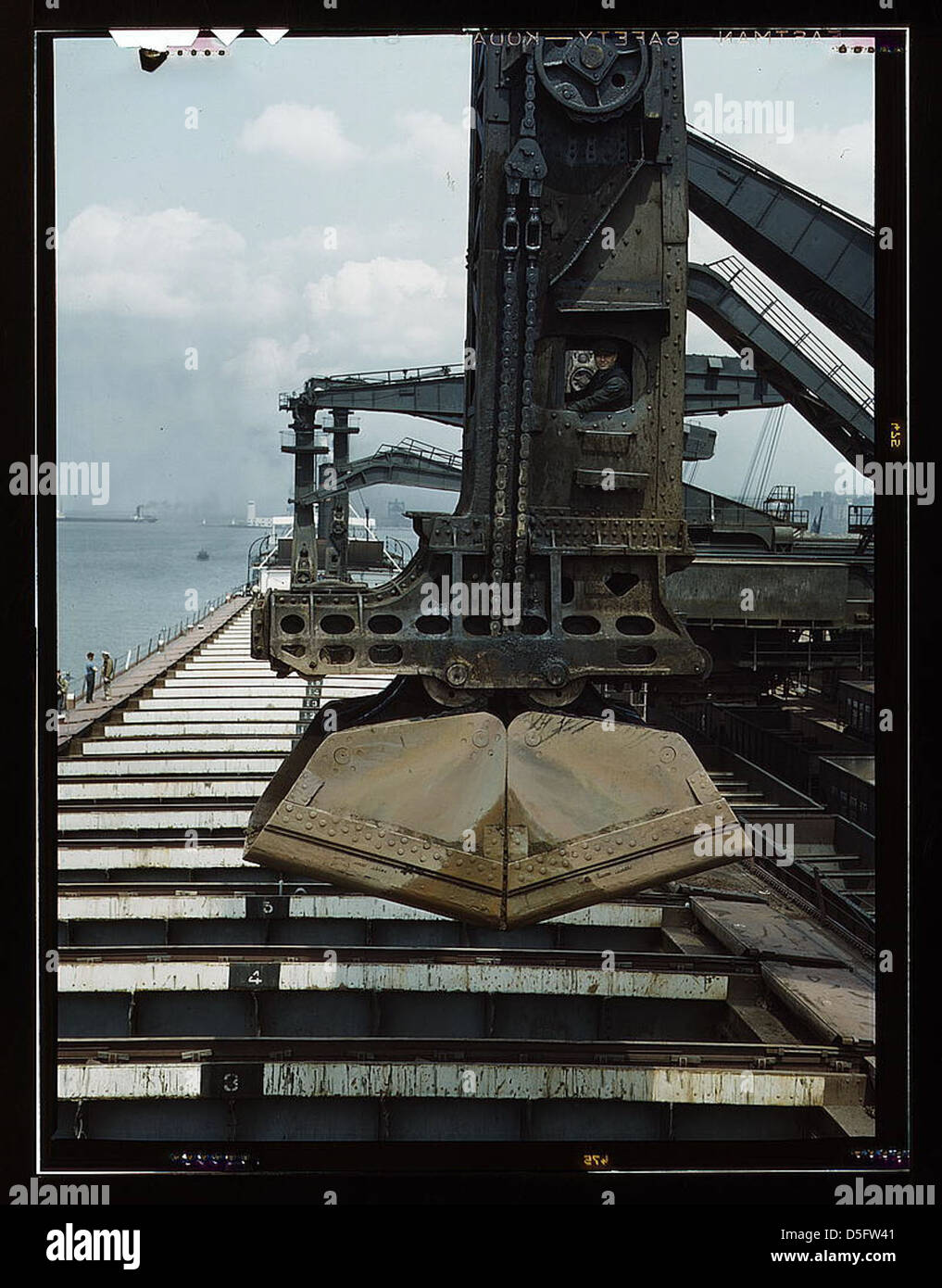 Dieses Foto zeigt das Entladen von Eisenerz aus einem Seefahrer an den Erzdocks der Pennsylvania Railroad in Cleveland, Ohio, mit dem Entlader „Hulett“, einer mechanischen Innovation für den Schüttguttransport. Stockfoto