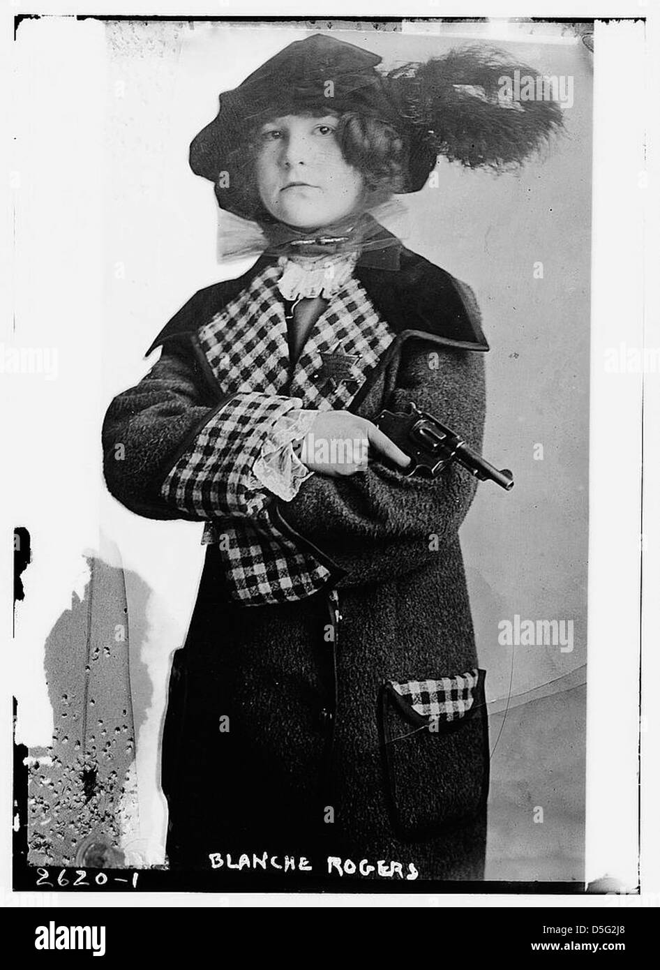 Blanche Rogers ist mit einer Pistole auf diesem Foto aus dem frühen 20. Jahrhundert dargestellt. Bekannt für ihre Beteiligung an verschiedenen Aktivitäten, wird sie mit einem Smith & Wesson Revolver gezeigt, der die Faszination der Ära für Frauen in unkonventionellen Rollen betont. Das Bild ist eine historische Darstellung der Geschlechternormen und gesellschaftlichen Erwartungen Anfang der 1900er Jahre Stockfoto